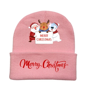 Close-up of pink knitted Christmas hat featuring reindeer and polar bear prints