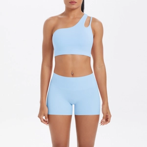 Detail of light blue one-shoulder yoga set showing cutout strap and matte fabric texture