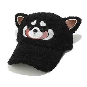 Détail d'une casquette noire en peluche avec oreilles d'ours et broderie mignonne