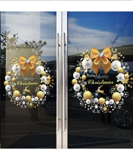 Close-up of golden Christmas window stickers with reindeer and snowflake motifs on glass