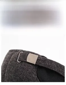 Detail of adjustable metal buckle and warm textured wool fabric on a men's winter cap