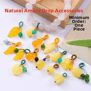 Detailed view of yellow amber resin charms in leaf and gourd shapes for DIY jewelry making