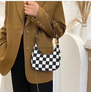 Detail of checkered hobo bag with metal chain strap and minimalist aesthetic styling