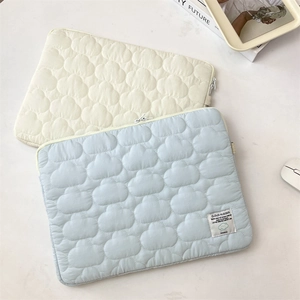 Detail of light blue cloud quilted laptop sleeve showing soft fabric texture and zipper