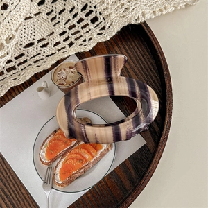 Close-up of cream tortoiseshell claw clip with France Handmade text on wooden tray