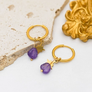 Detailed shot of gold plated hoop earrings with purple natural stone and star pendants
