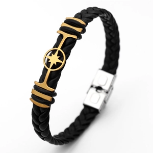 Close-up of black braided leather men's bracelet with gold maple leaf and silver buckle