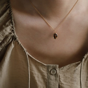 Close-up of a model wearing the gold tiger eye stone coffee bean pendant necklace