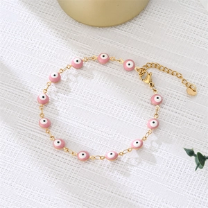 Detail of gold evil eye bracelet with pink enamel beads and adjustable lobster clasp