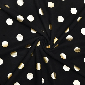 Dettaglio del tessuto in chiffon nero con pois dorati metallizzati e texture a pieghe