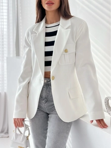 Dettaglio blazer bianco con mini borsa e crop top a righe sotto la luce del sole