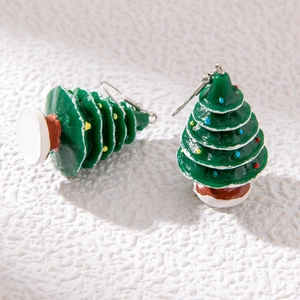 Detailed close-up of green Christmas tree drop earrings with colorful dot patterns