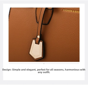 Detail of brown litchi pattern leather texture and golden metal pendant on handbag