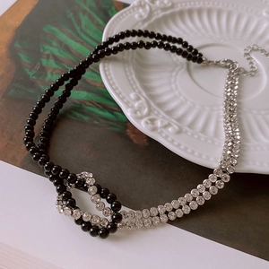 Detail of double-layer choker featuring black beads, sparkling rhinestones, and knot clasp
