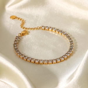 Detail von 18K Gold-Edelstahl-Tennisarmband mit weißen Zirkonen auf Seidenhintergrund