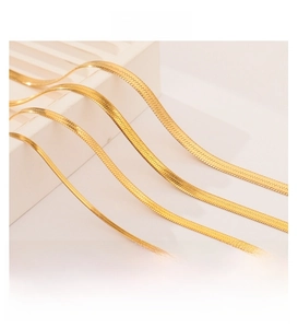 Detail view of 18K gold plated herringbone snake chain necklaces on white display