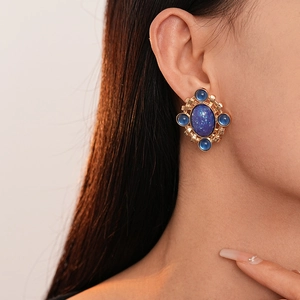 French vintage style gold oval blue gemstone earrings with crystal accents on ear