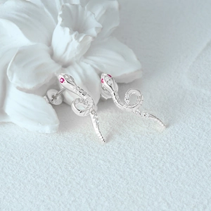Macro view of S925 sterling silver snake stud earring with white and red zircon stones
