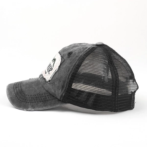 Side view of washed distressed trucker hat featuring mesh back and TRUCKER patch detail