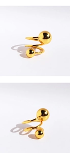 Detailed macro view of a golden spiral ring with two polished spheres on a white background
