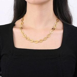 Close-up of a gold stainless steel oval link chain necklace worn on a fashion model