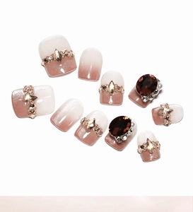 Detail of French cat eye ombre press-on nails with luxury rhinestones and jewels
