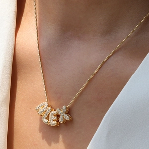 Macro shot of 18k gold plated ALEX bubble letter pendant with sparkling pavé crystals