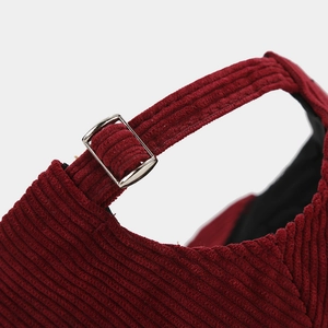 Detail shot of the adjustable silver metal buckle on red corduroy baseball cap