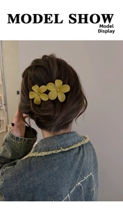 Detail of matte ginger flower hair claw clips worn on hair for styling decoration