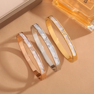 Close-up of titanium steel bracelets with white shell inlay and sparkling diamonds