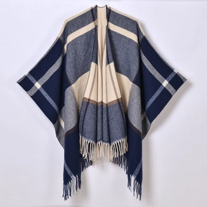 Detail eines klassisch blau-beigen Plaid-Ponchos mit Fransen und weicher Strickstruktur