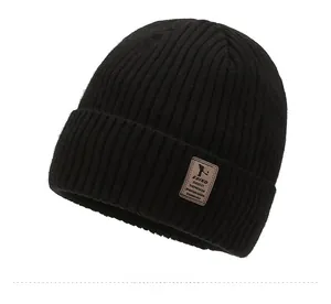 Close-up of black ribbed knit beanie featuring a brown vintage leather patch detail