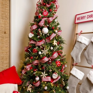 Dettaglio di un albero di Natale decorato con nastri a quadri rossi e bianchi e decorazioni