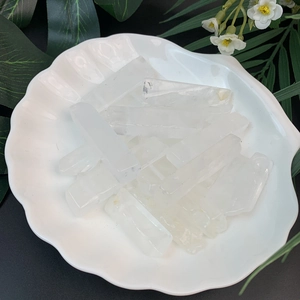 Translucent white crystal points displayed in a white seashell-shaped ceramic bowl