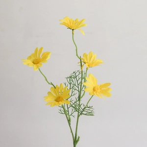Detailed close-up of yellow artificial daisy stem with realistic green leaves and fabric petals