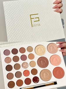 Detail view of a 26-color makeup palette with matte and shimmer eyeshadows and a brush