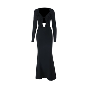 Detalle de vestido negro de manga larga con cuello en V, volantes y corte en cintura