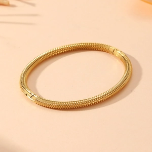 Detailed view of golden stainless steel bracelet featuring textured surface and clasp