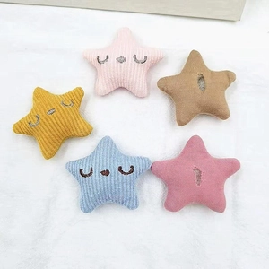 Macro detail of knit star-shaped accessories in various pastel colors on a soft fabric