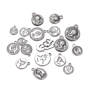 Detailed close-up of antique silver coin charms with embossed Queen Elizabeth portrait