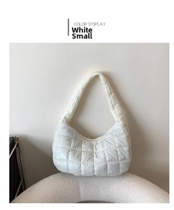 Detailed view of white small quilted puffy shoulder bag on a soft fleece chair