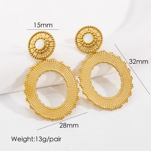 Detail of bohemian gold earrings with natural stone inlay and sunburst etched pattern