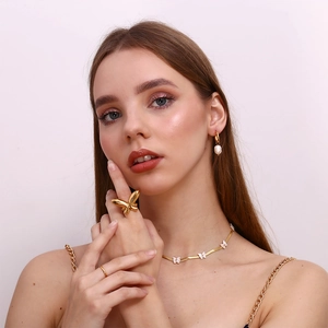 Detail of 18K gold plated shell butterfly necklace and pearl jewelry set on model