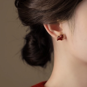 Élégantes boucles d'oreilles pégase rouges avec ailes dorées sur un mannequin