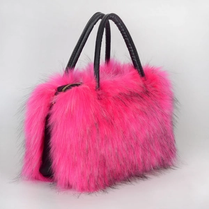 Detailed view of pink faux fur tote bag with black leather handles and zipper closure