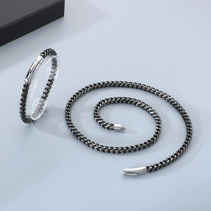 Détail du parure collier et bracelet en chaîne maille d'acier inoxydable argent et noir