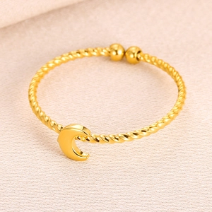 Detail view of a gold-plated twisted rope cuff bracelet with a polished moon pendant