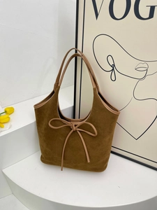 Retro brown frosted bucket bag with butterfly knot detail shown in a minimalist studio