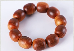 Macro shot of 12 polished wooden barrel beads featuring natural brown grain patterns