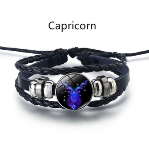 Gros plan d'un bracelet en cuir Capricorne avec un dôme zodiacal bleu lumineux